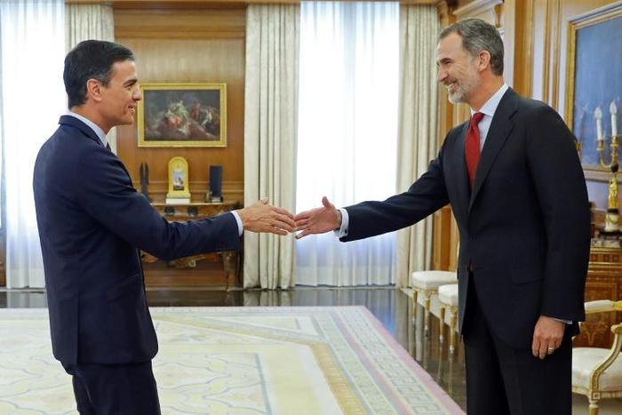 Spain's King Felipe VI (R) greets Spanish Prime Minister and Socialist Party leader Pedro Sanchez upon his arrival for a meeting at the Zarzuela Palace in Madrid