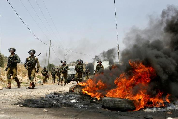 Israeli security forces take position during a weekly demonstration by Palestinians against the expropriation of their lands by Israel in the village of Kfar Qaddum, near Nablus in the occupied West Bank