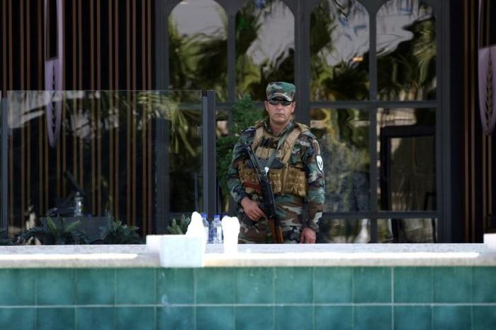 A member of the Iraqi Kurdish security forces stands guard outside the restaurant where two people were shot dead in Arbil