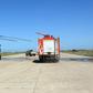 In this file photo, a firefighting truck is parked next to an Italian-built Libyan Chinook CH-47 military helicopter that was hit by shrapnel following an air strike at Mitiga International Airport in early April