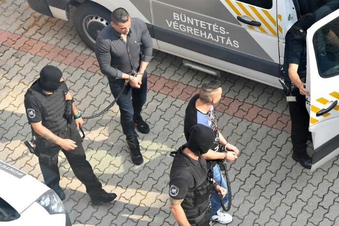 Defendants were escorted by police officers as they arrived in court for the final verdict