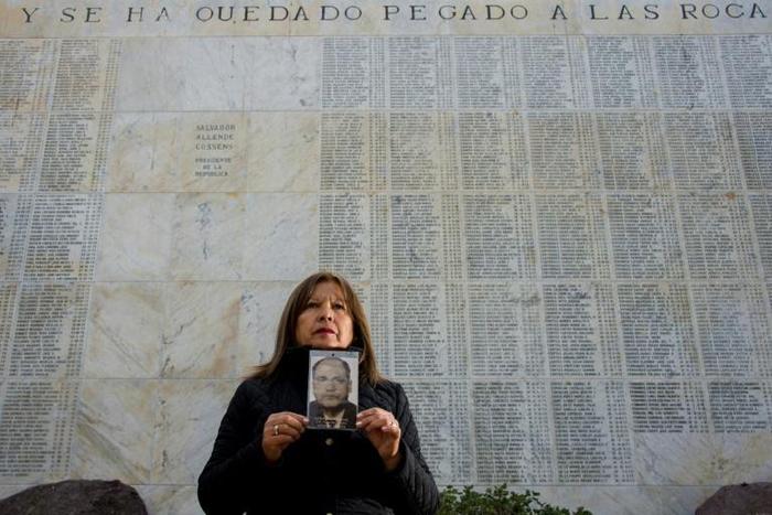 Juana Cerda, daughter of Cesar Cerda who disappeared during the 1973-1990 military dictatorship of Augusto Pinochet in Chile, holds up an image of her father on May 16, 2019