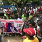 Demonstrators hold a poster portraying Liberian President George Weah as they gather outside the Liberian Mansion in Monrovia on June 7, 2019 during an anti-government march to protest inflation and corruption