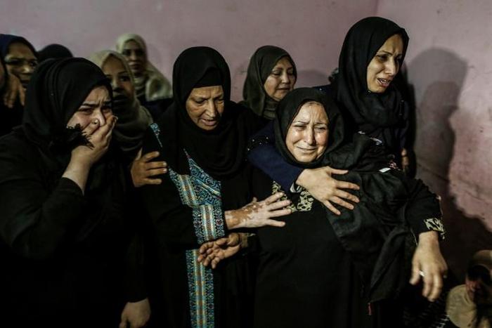 Relatives mourn for one of three Palestinians killed by Israeli fire along the border with the Gaza Strip