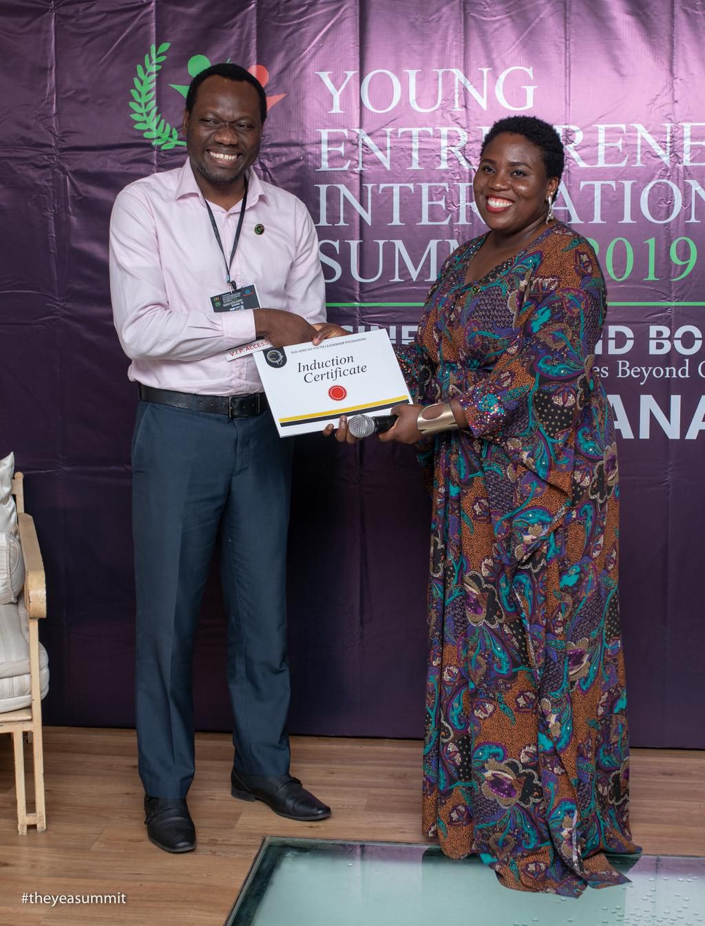 Ibukun Onitiju (left) receives his Induction Certificate at YEIS