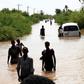 Sudanese people walk a flooded road in Wad Ramli village on the eastern banks of the Nile river