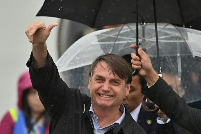 Brazilian President Jair Bolsonaro gives the thumbs-up sign as he arrives in Osaka for the G20 summit