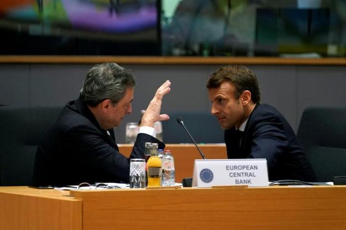 European Central Bank President Mario Draghi and France's President Emmanuel Macron (R) speaking before a meeting