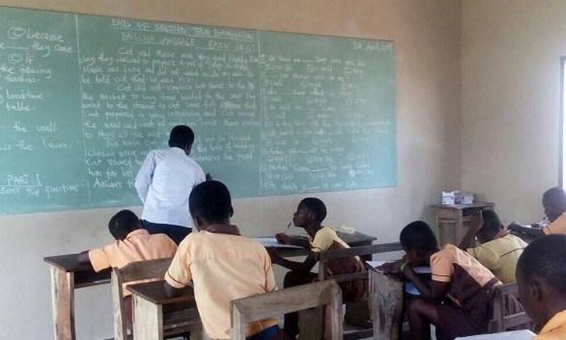 Teachers write exam questions on blackboards