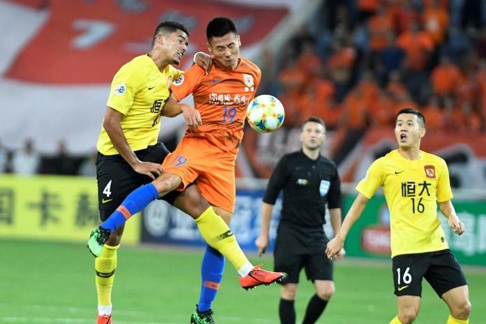 Song Wenjie (C) of Shandong Luneng competes for the ball with Tyias Browning (L) of Guangzhou Evergrande. Evergrande shaded their Chinese rivals 6-5 on penalties