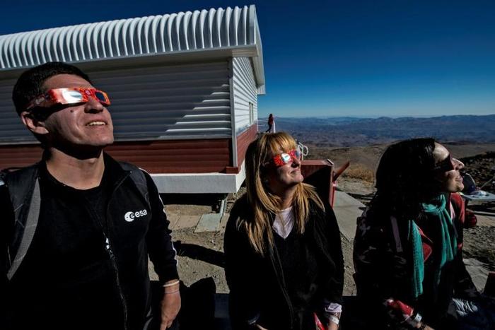 Tourists wear special glasses ahead of a solar eclipse at La Silla European Southern Observatory at La Higuera in Chile's Coquimbo Region on July 2, 2019