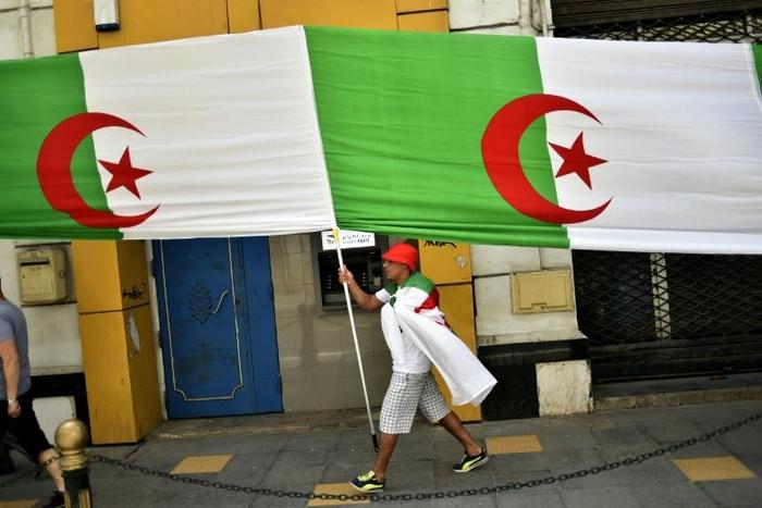 An Algerian man clad in a national flag takes part in a demonstration in the capital Algiers on June 14