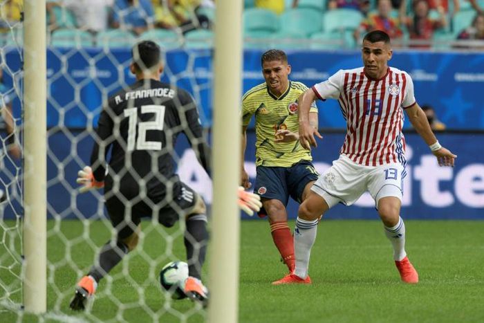 Colombia's Gustavo Cuellar (center) scores through Paraguay goalkeeper Roberto Fernandez's legs