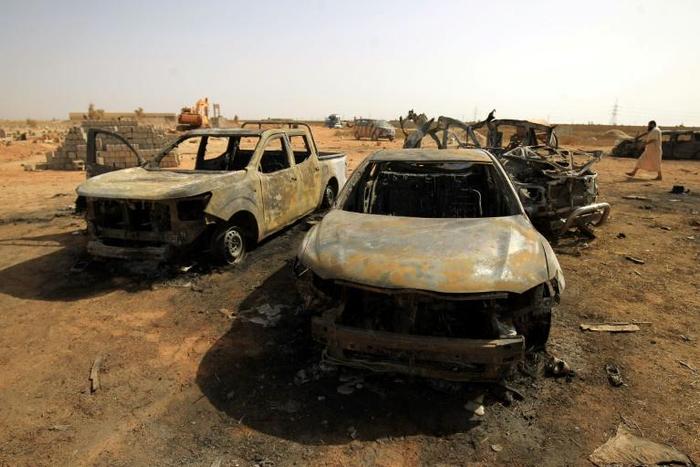 Damaged cars at the site of a bomb attack that targeted servicemen during the funeral of an ex-army commander in the Libyan city of Benghazi