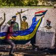 A Sudanese protester runs past a mural during a demonstration near army headquarters in the capital Khartoum back in April