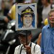 A man in Caracas holds up a portrait of Venezuelan retired naval officer Rafael Acosta, who was allegedly tortured before his death