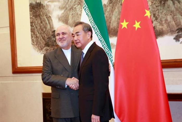 Chinese Foreign Minister Wang Yi shakes hands with Iranian Foreign Minister Mohammad Javad Zarif at the Diaoyutai State Guesthouse in Beijing