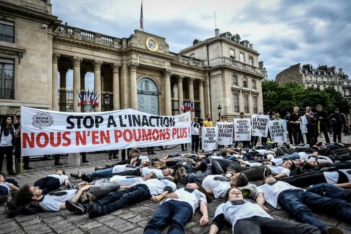Activists stage a "die-in" on June 4, 2019 to denounce the air quality outside the French National Assembly in Paris