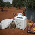A Syrian girl stands behind family belongings near a camp for displaced people in the village of Atme, northern Idlib province