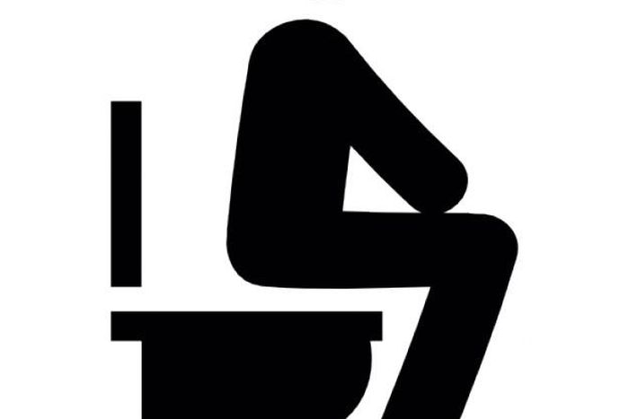 Silhouette of a man sitting on a toilet bowl