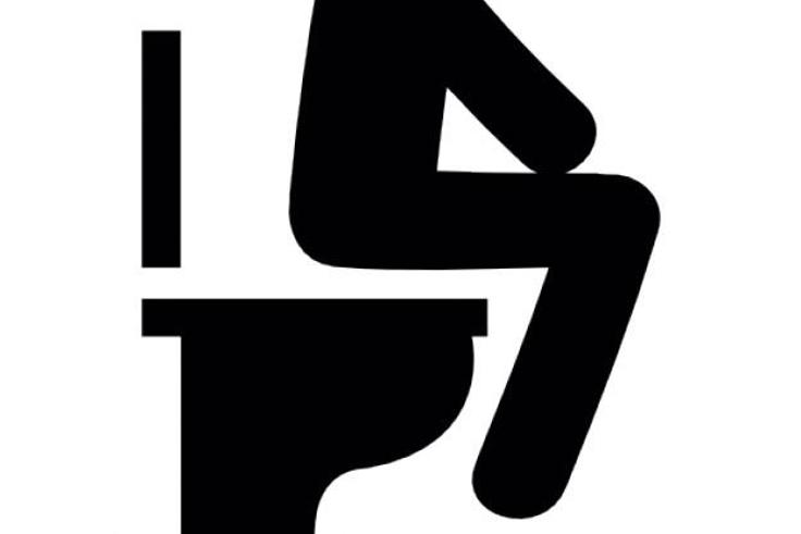 Silhouette of a man sitting on a toilet bowl
