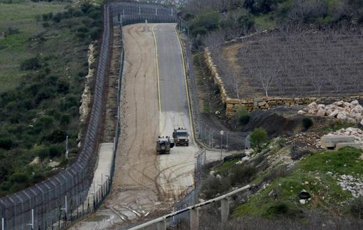 Israeli military vehicles patrol the border fence with Syria in the Israeli-annexed Golan Heights