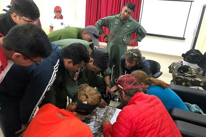 Mountaineers and rescuers study a map of Nanda Devi in an effort to pinpoint the location of the missing climbers on June 3, 2019