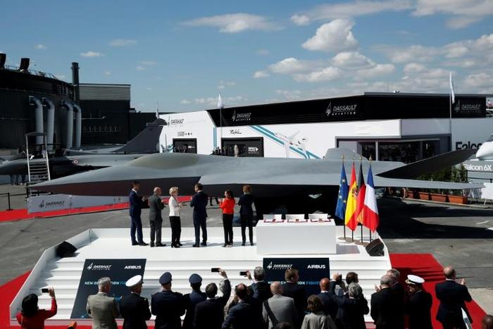 French President Emmanuel Macron, third from right, joined other officials in front of a full-scale model of new jet for Europe's Future Combat Air System (FCAS) at the Paris Air Show on Monday