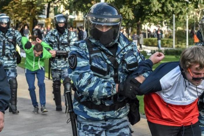 Russian National Guard officers detain protesters following a rally calling for fair elections in Moscow
