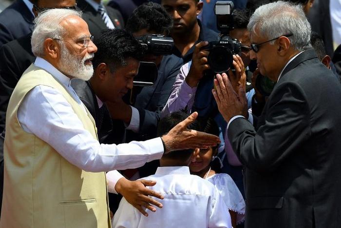 Sri Lankan Prime Minister Ranil Wickremesinghe (right) welcomes Indian Prime Minister Narendra Modi at Bandaranaike International Airport in Katunayake