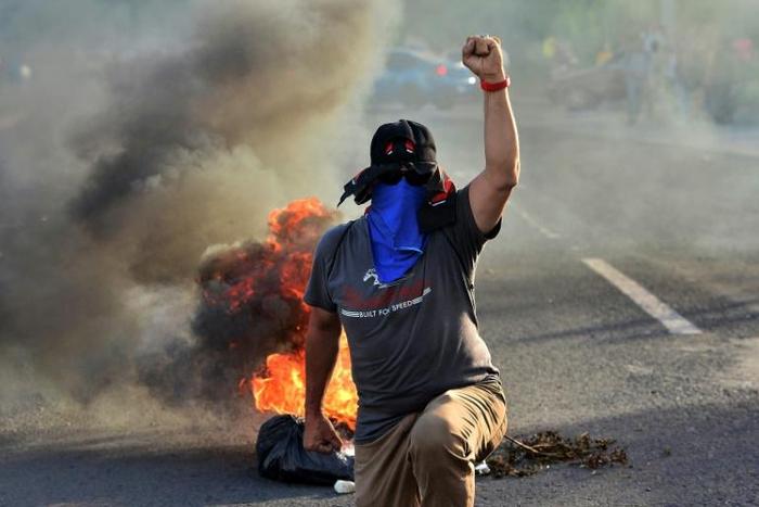 Honduran colleges students block a road in the capital Tegucigalpa during a protest against the government of President Juan Orlando Hernandez