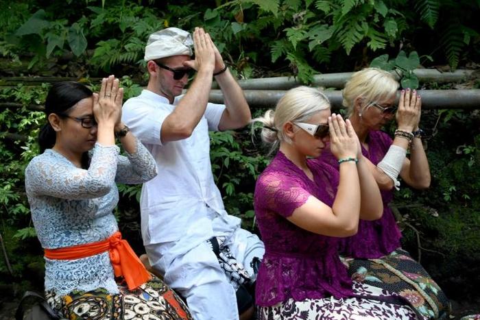 Czech nationals Sabina Dolezalova (2nd R) and her boyfriend Zdenek Slouka (2nd L) took part in a purification ritual in Bali after a disrespectful online video they posted went viral