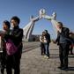 Tourists from China pose for photos before the Three Charters monument in the North Korean capital Pyongyang