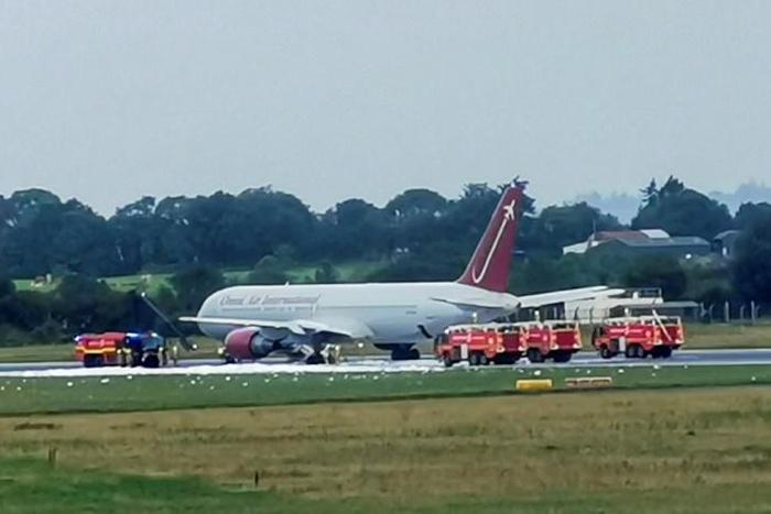 Firecrews attend an Omni Air International aircraft on the tarmac at Shannon Airport in County Clare, western Ireland, after a fire broke out on the undercarriage of the plane on the runway