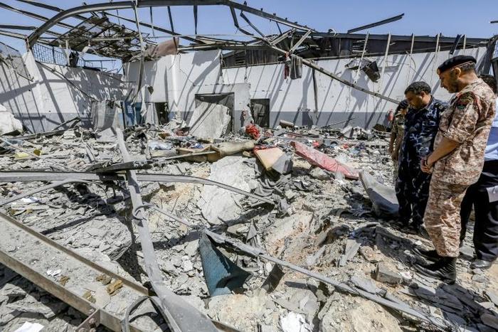 Military officers of the Libyan Government of National Accord (GNA)inspect damage at a migrant detention center in the capital Tripoli's southern suburb of Tajoura on July 3, 2019, following an air strike on a nearby building that left dozens killed
