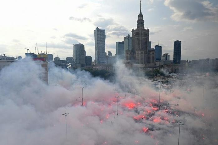 People lit flares as they observed a minute of silence to mark the 75th anniversary of the Warsaw Uprising against the Nazi occupiers during World War II