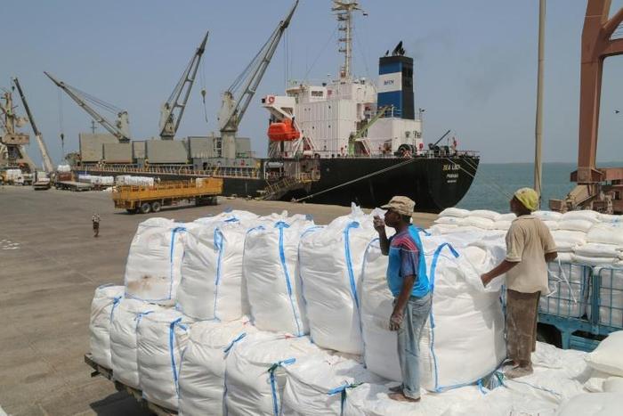 Yemenis receive sacks of food aid packages from the World Food Programme (WFP) in the Yemeni port city of Hodeida on June 25, 2019