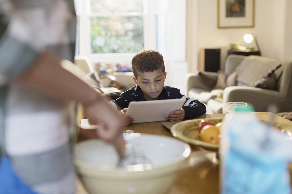 Curious boy using digital tablet in kitchen