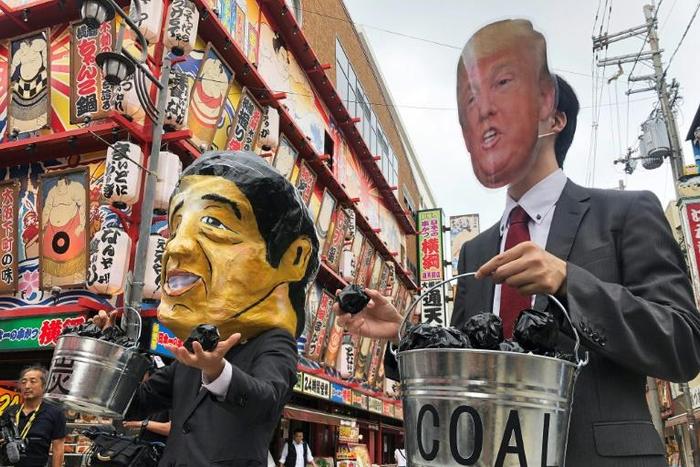 Protesters wearing masks of world leaders including Japan's Prime Minister Shinzo Abe and US President Donald Trump demonstrate against climate change at the G20 summit in Osaka