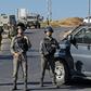 Israeli soldiers stand guard next to the site where the soldier's body was found near the settlement of Migdal Oz in the occupied West Bank