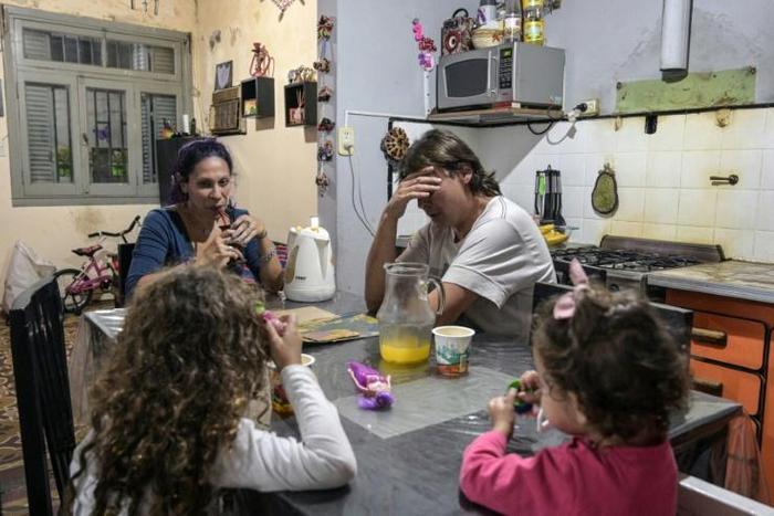 Between the two of them, Argentine couple carpenter Ariel Fernandez (2nd R) and his wife, teacher Natalia Morales (L), earn the equivalent of around $1,200 a month as more and more people in the country fall below the poverty line