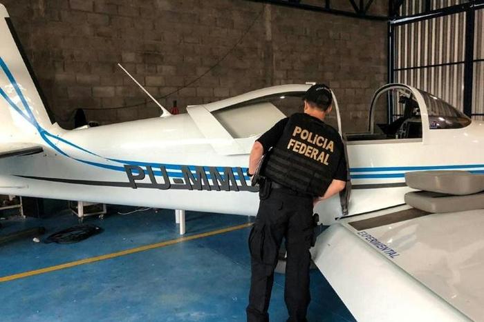 A federal police officer inspects an airplane seized during an anti drugs sweep in February 2019 at a hangar in Palmas, Tocatins state, central Brazil