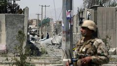 An Afghan security personnel stands guard at the site where a Taliban car bomb detonated at the entrance of a police station in Kabul on August 7