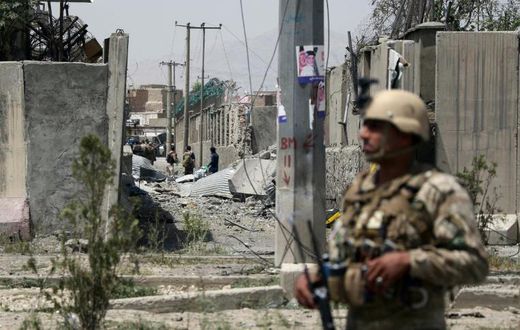 An Afghan security personnel stands guard at the site where a Taliban car bomb detonated at the entrance of a police station in Kabul on August 7