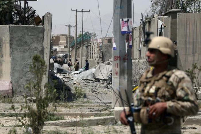 An Afghan security personnel stands guard at the site where a Taliban car bomb detonated at the entrance of a police station in Kabul on August 7