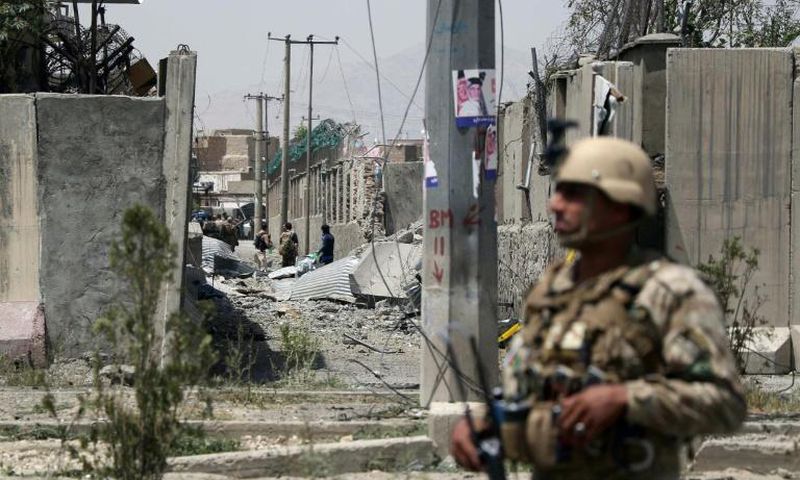 An Afghan security personnel stands guard at the site where a Taliban car bomb detonated at the entrance of a police station in Kabul on August 7