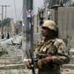 An Afghan security personnel stands guard at the site where a Taliban car bomb detonated at the entrance of a police station in Kabul on August 7