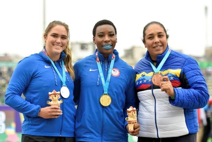 Gwen Berry poses with her gold medal after she had raised a clenched fist on the podium