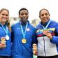 Gwen Berry poses with her gold medal after she had raised a clenched fist on the podium