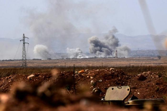 Smoke billows from buildings in the jihadist-held village of Tal Maleh in northwest Syria's Hama province shows on June 9, 2019 as pro-regime forces pound the site